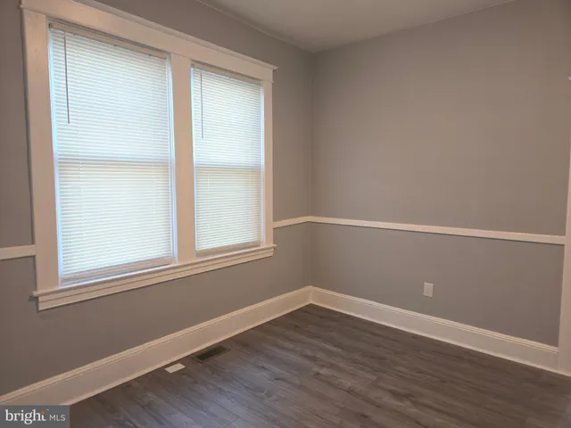 a view of a small space with wooden floor and a window