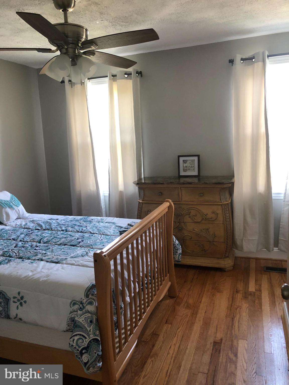 3541 Benzinger Road Baltimore, MD 21229 - Photo 23 of 33 a bedroom with a bed and wooden floor