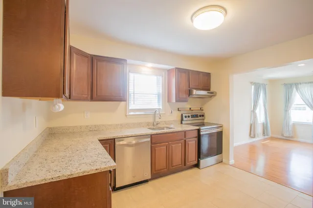 a kitchen with stainless steel appliances granite countertop a sink stove and cabinets