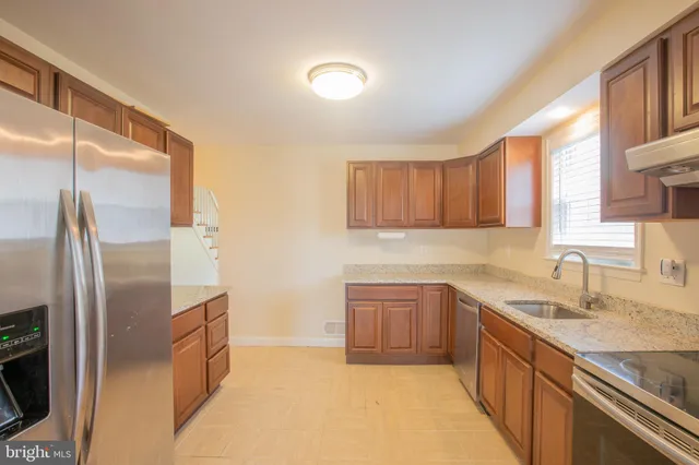 a kitchen with stainless steel appliances granite countertop a refrigerator and a sink