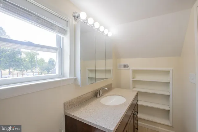 a bathroom with a sink vanity granite and a mirror