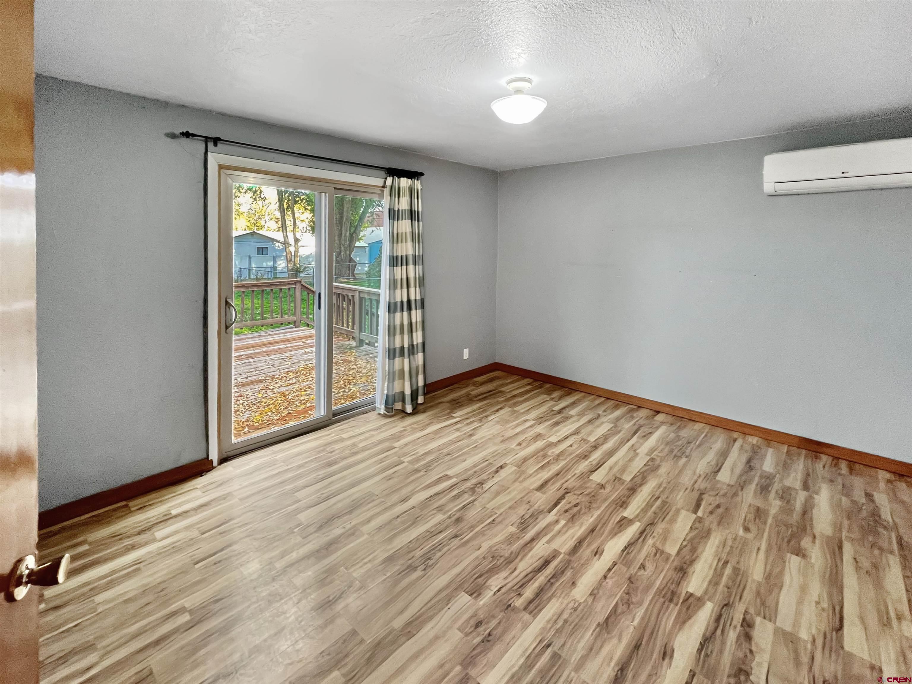 112 North Adams Street Cortez, CO 81321 - Photo 11 of 20 wooden floor in an empty room with a window