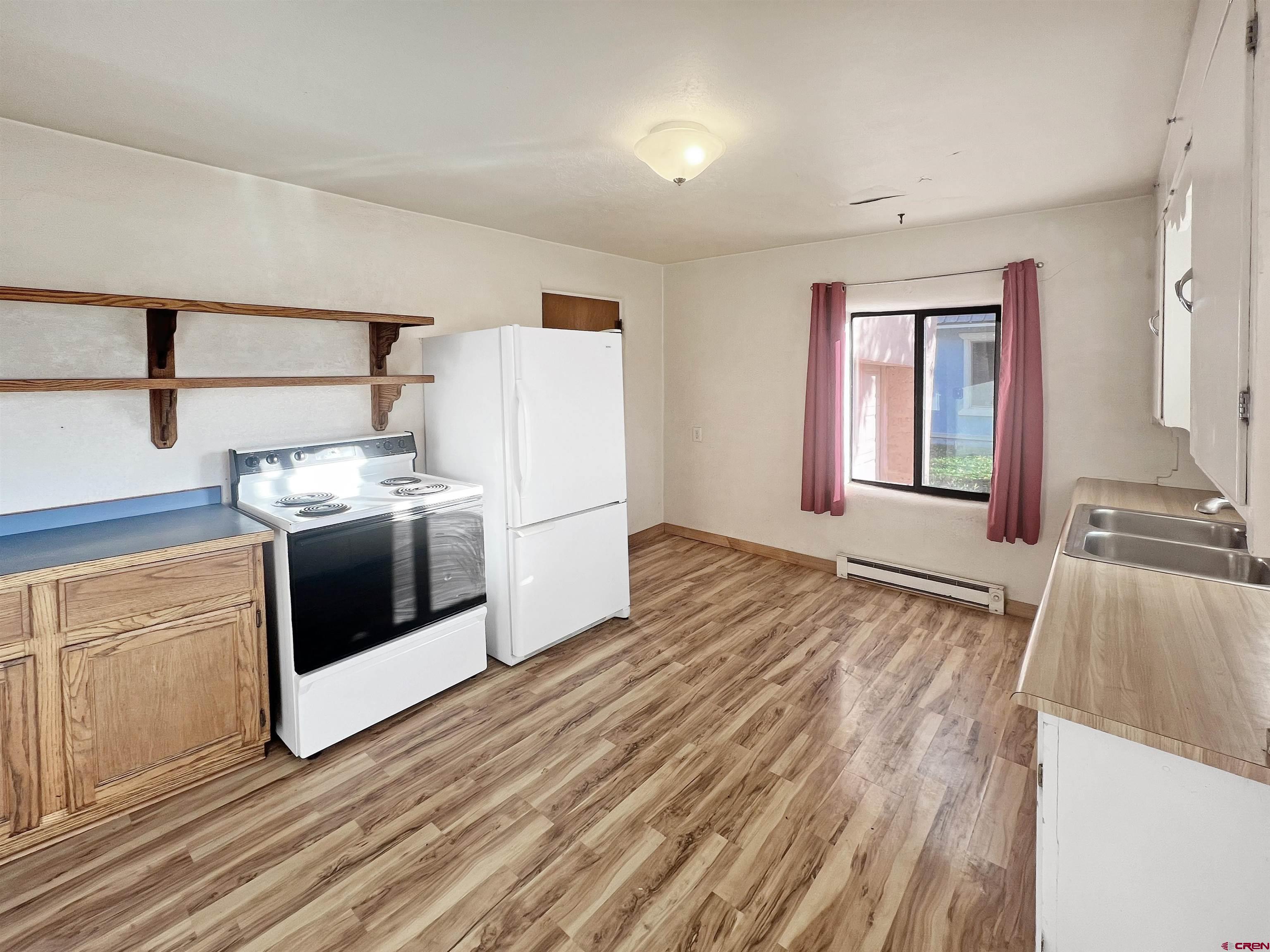 112 North Adams Street Cortez, CO 81321 - Photo 6 of 20 a kitchen with a stove a sink and a refrigerator
