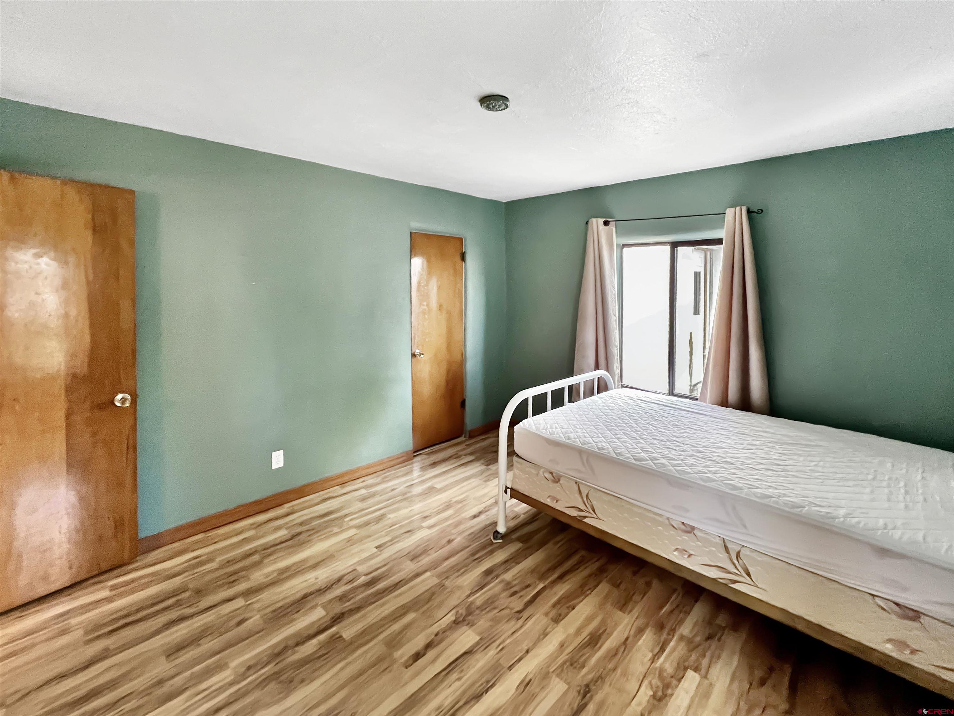 112 North Adams Street Cortez, CO 81321 - Photo 9 of 20 a bedroom with a bed and window