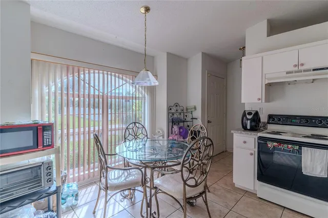 a kitchen with stainless steel appliances a stove a chandelier a dining table and chairs