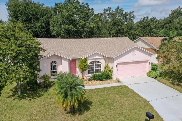 an aerial view of house with yard and trees in the background
