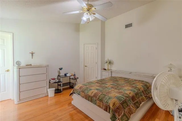 a bedroom with a bed and a chandelier fan