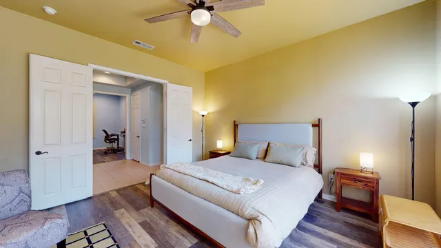 a bedroom with a bed and a chandelier fan