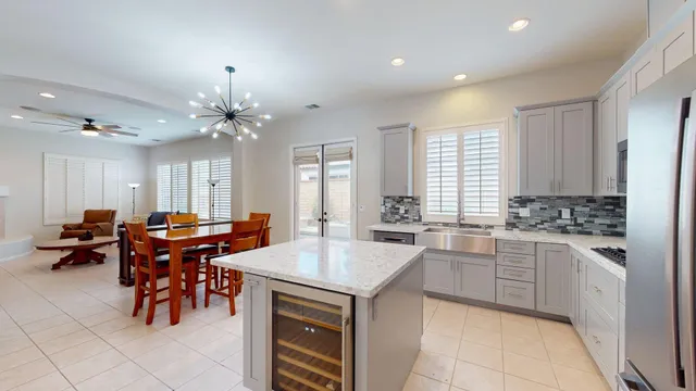 a large kitchen with granite countertop a stove a sink a dining table and chairs
