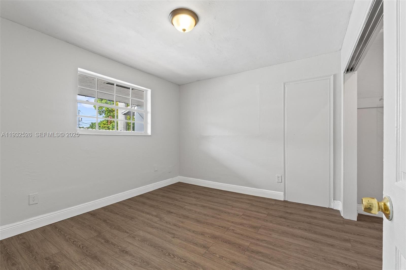 11441 Southwest 2nd Street, Unit 11443 Sweetwater, FL 33174 - Photo 15 of 31 wooden floor in an empty room with a window