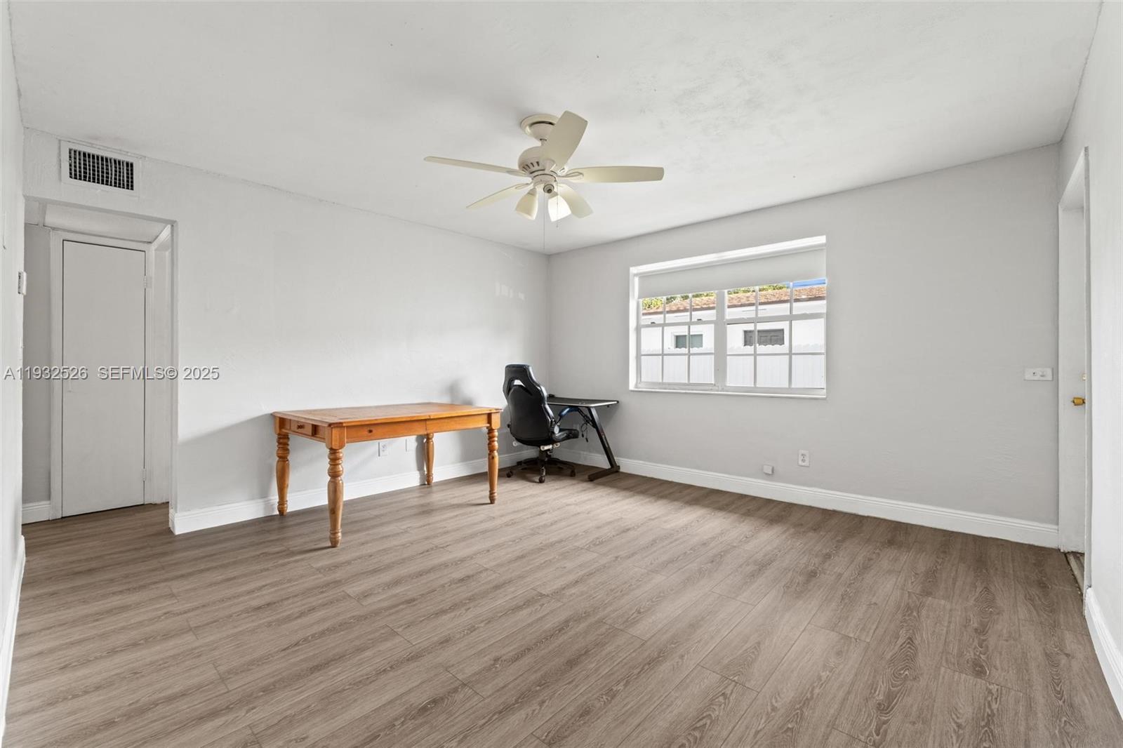 11441 Southwest 2nd Street, Unit 11443 Sweetwater, FL 33174 - Photo 6 of 31 a view of an empty room with wooden floor and a window