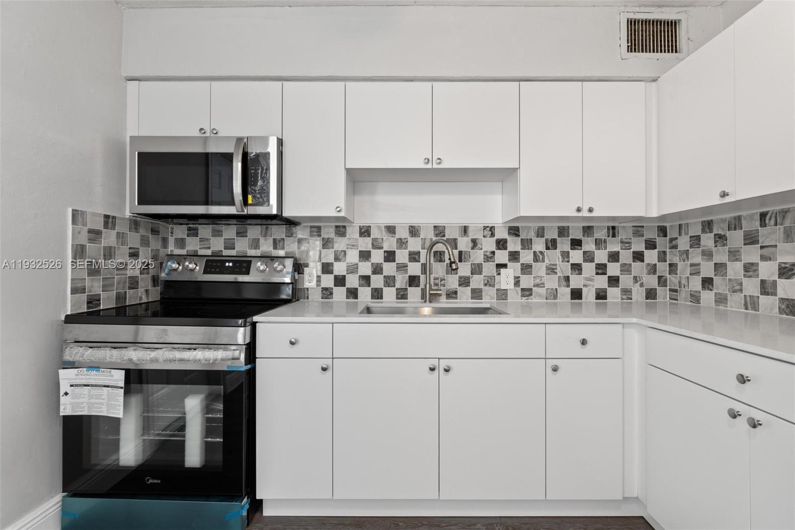 11441 Southwest 2nd Street, Unit 11443 Sweetwater, FL 33174 - Photo 10 of 31 a kitchen with white cabinets and appliances