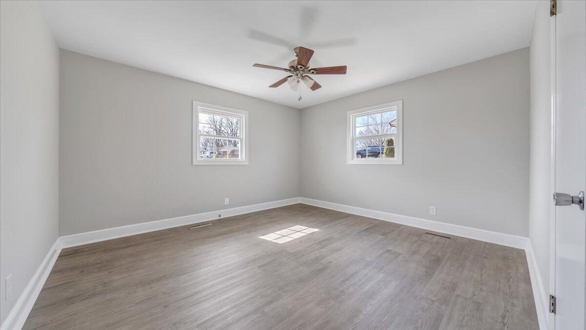 200 Cornell Road Rocky Mount, VA 24151 - Photo 18 of 44 an empty room with wooden floor ceiling fan and windows