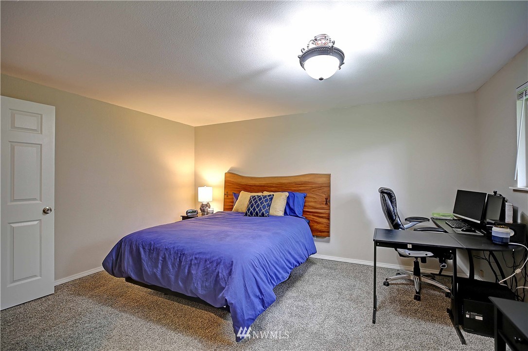 4415 212th Street Southeast Bothell, WA 98021 - Photo 14 of 29 a bedroom with a bed and a chandelier