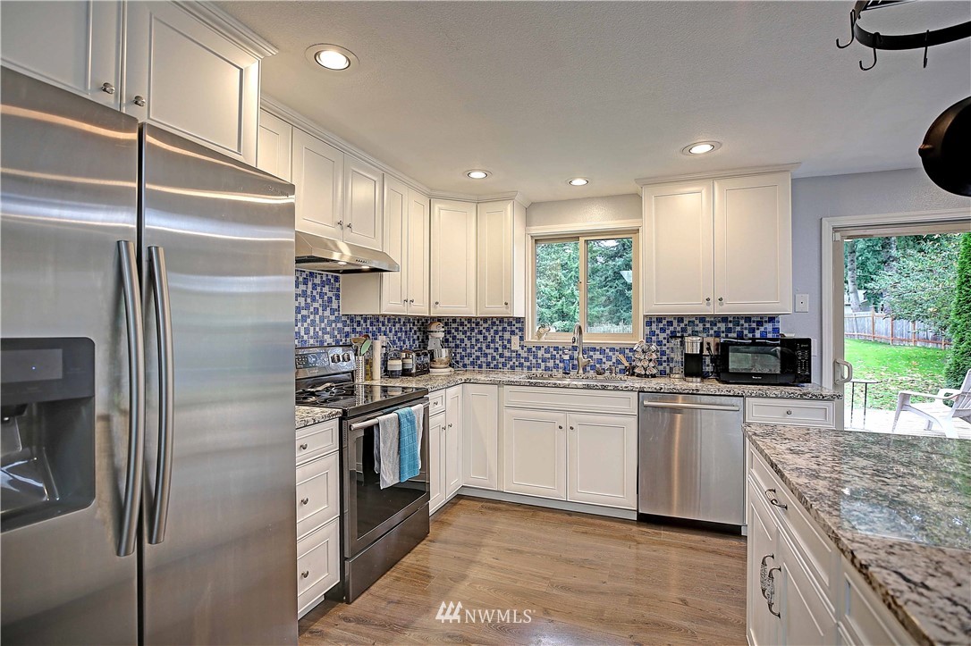 4415 212th Street Southeast Bothell, WA 98021 - Photo 7 of 29 a kitchen with stainless steel appliances granite countertop a sink a stove a refrigerator and a refrigerator