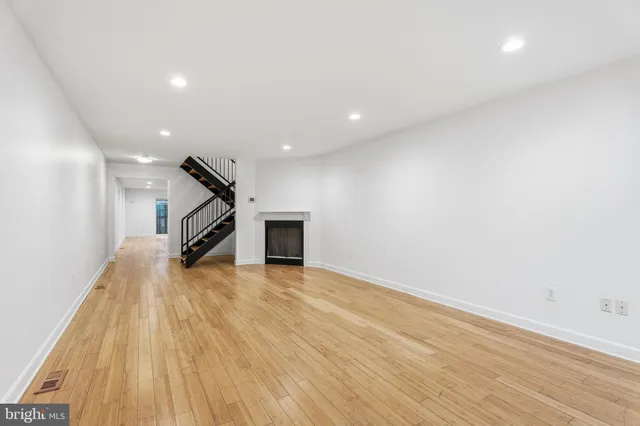 a view of a livingroom with wooden floor and a ceiling fan
