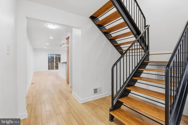 a view of a hallway with wooden floor and stairs