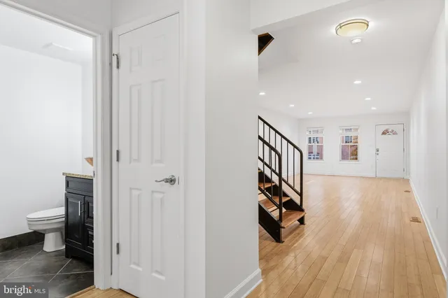a view of a hallway with wooden floor and staircase