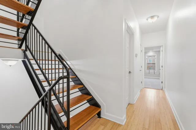 a view of a hallway with wooden floor and staircase