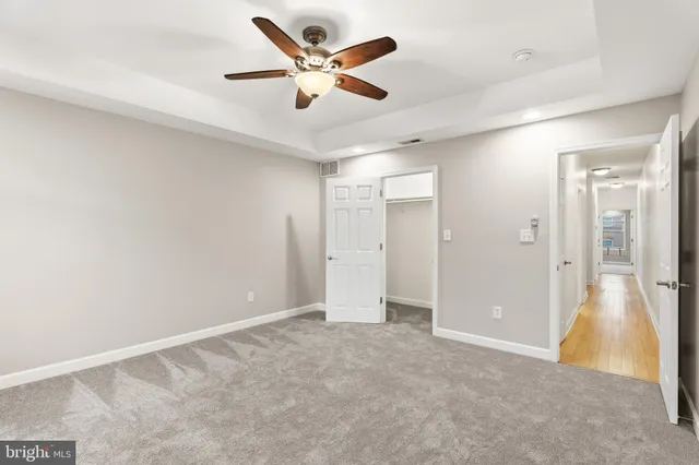 an empty room with a ceiling fan and a window