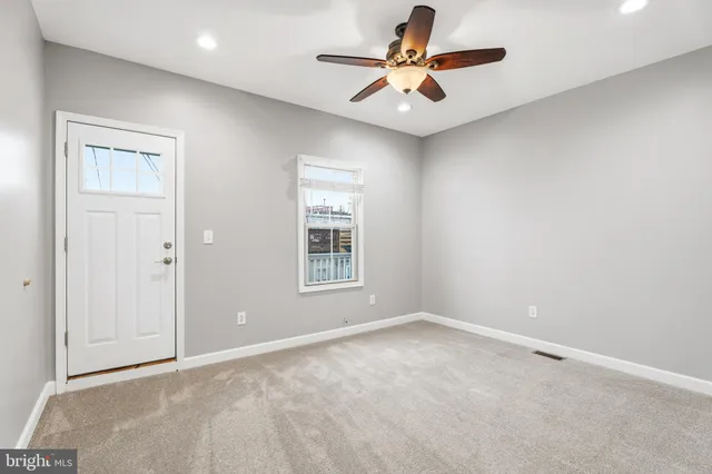 an empty room with a window and a fan