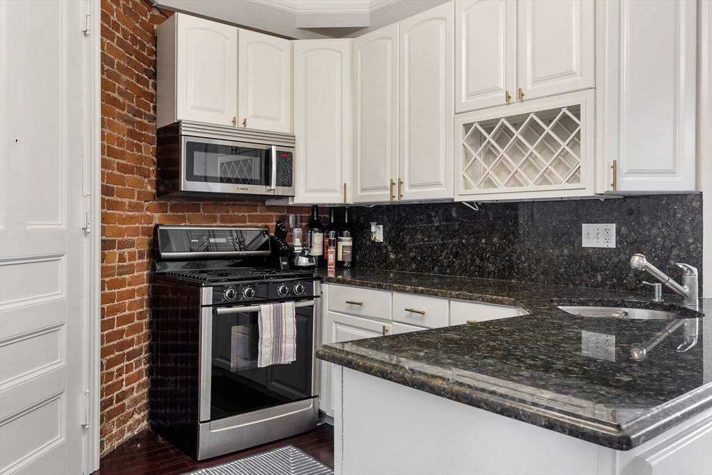 362 Commonwealth Avenue, Unit 4A Boston, MA 02115 - Photo 15 of 23 a kitchen with stainless steel appliances granite countertop a sink stove and microwave