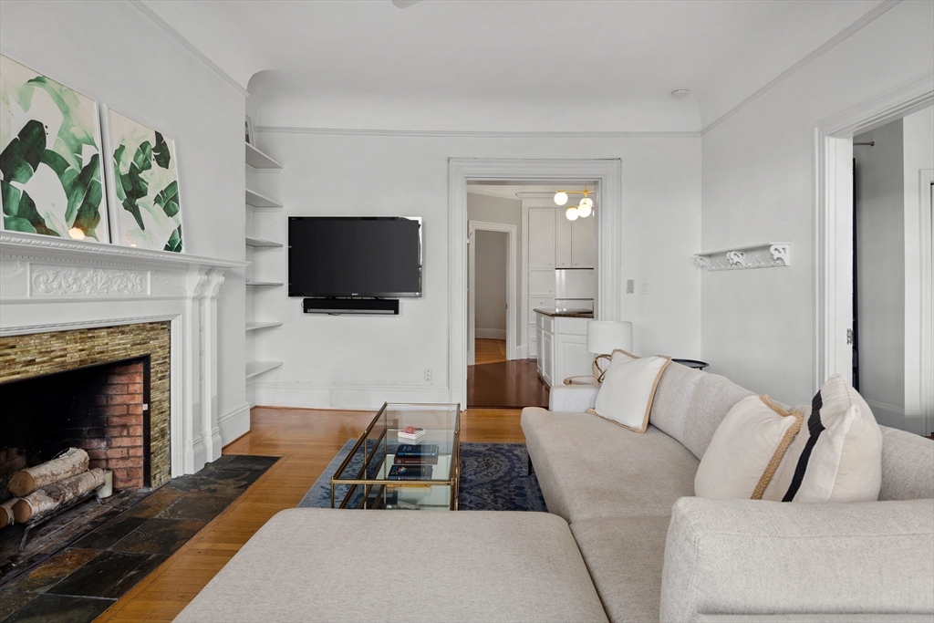 362 Commonwealth Avenue, Unit 4A Boston, MA 02115 - Photo 5 of 23 a living room with furniture a flat screen tv and a fireplace