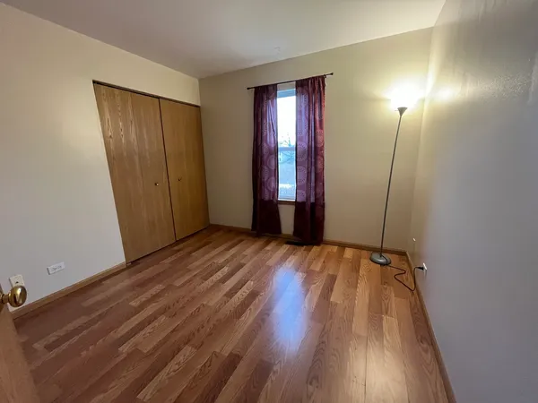 an empty room with closet and wooden floor