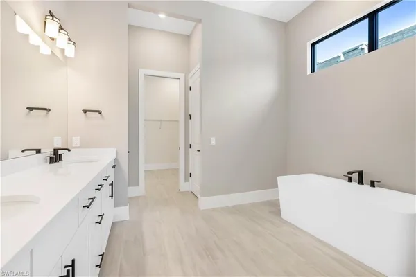 a spacious bathroom with a granite countertop sink mirror shower and a bathtub