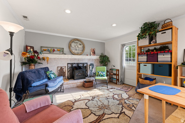 12152 Cinnamon Ridge Road Sandy, UT 84094 - Photo 23 of 51 Living area featuring a white-painted brick fireplace with a dark metal firebox insert, recessed ceiling lighting, and crown molding