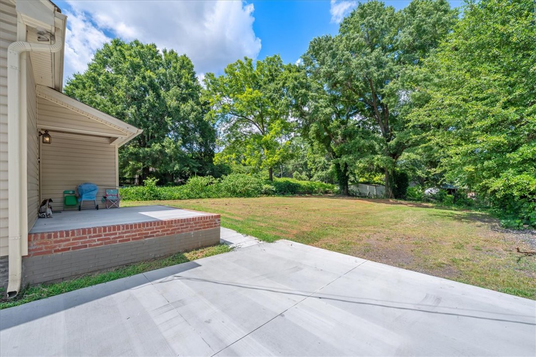 1102 West End Avenue Anderson, SC 29625 - Photo 24 of 28 A spacious backyard with mature trees offers a serene natural setting.
