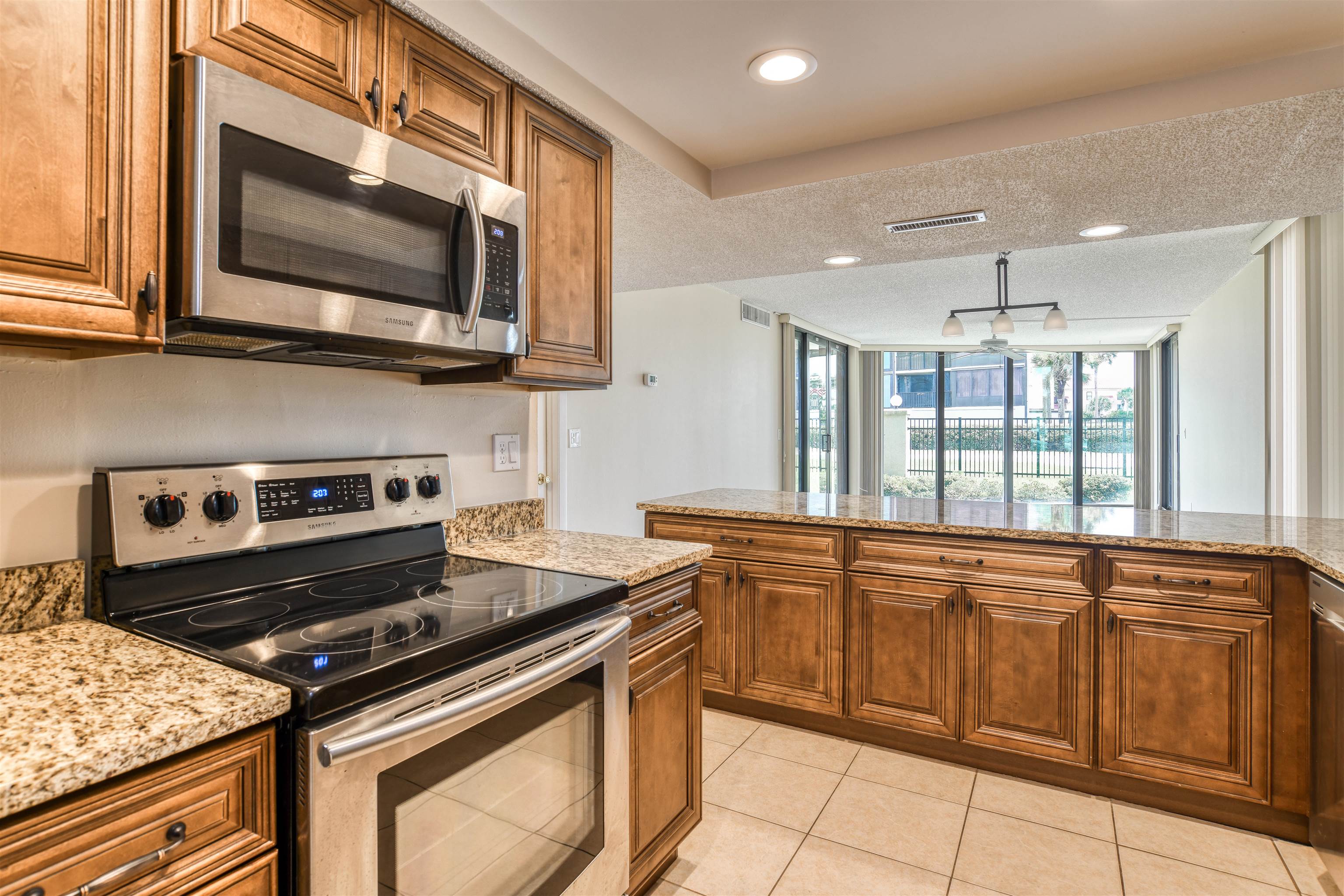 2 Dondanville Road, Unit 101 St. Augustine, FL 32080 - Photo 11 of 50 a kitchen with stainless steel appliances granite countertop a stove and a microwave