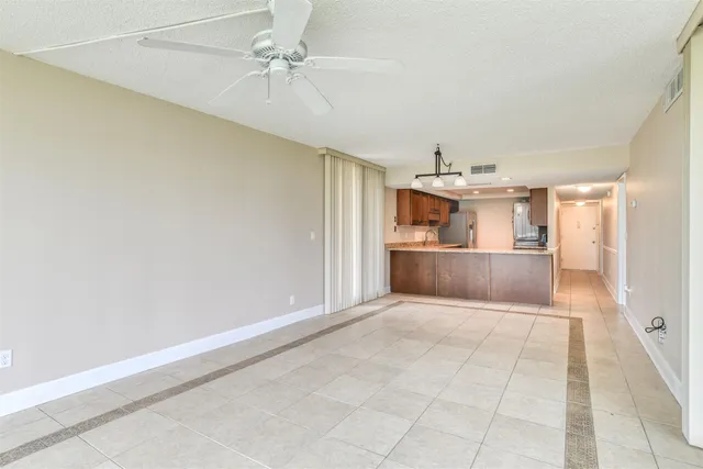 an empty room with cabinet and windows