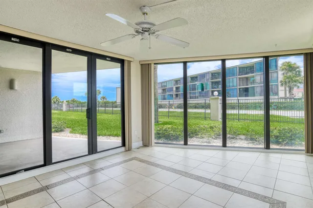 a view of an empty room and window ceiling fan