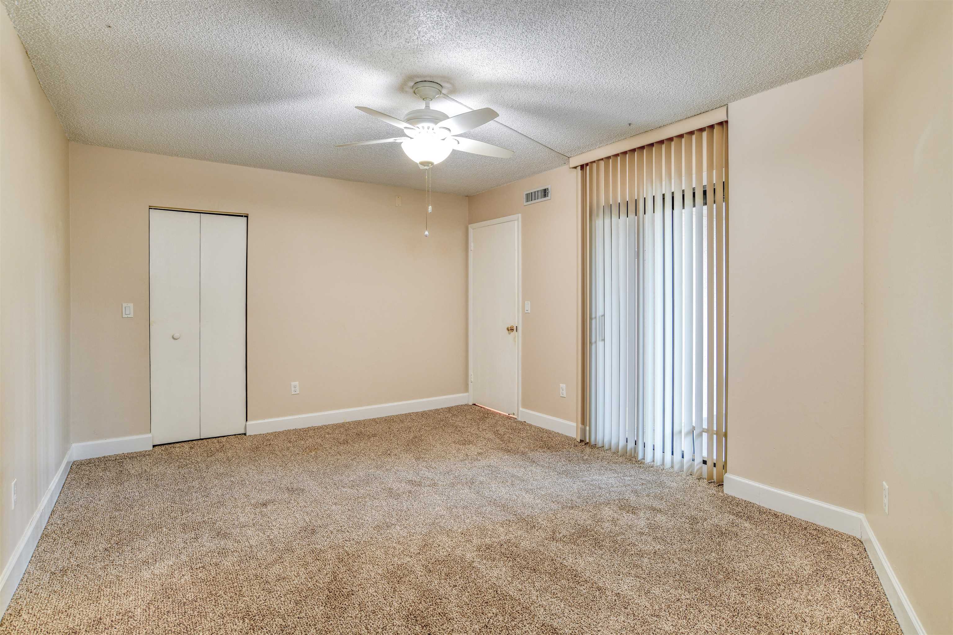 2 Dondanville Road, Unit 101 St. Augustine, FL 32080 - Photo 25 of 50 an empty room with a chandelier fan and windows