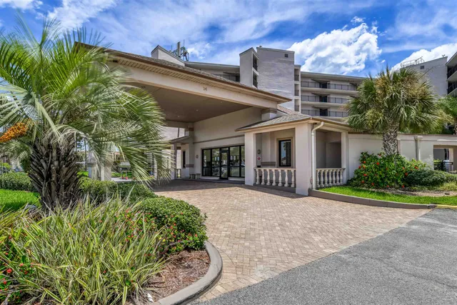 a view of a house with a yard and potted plants