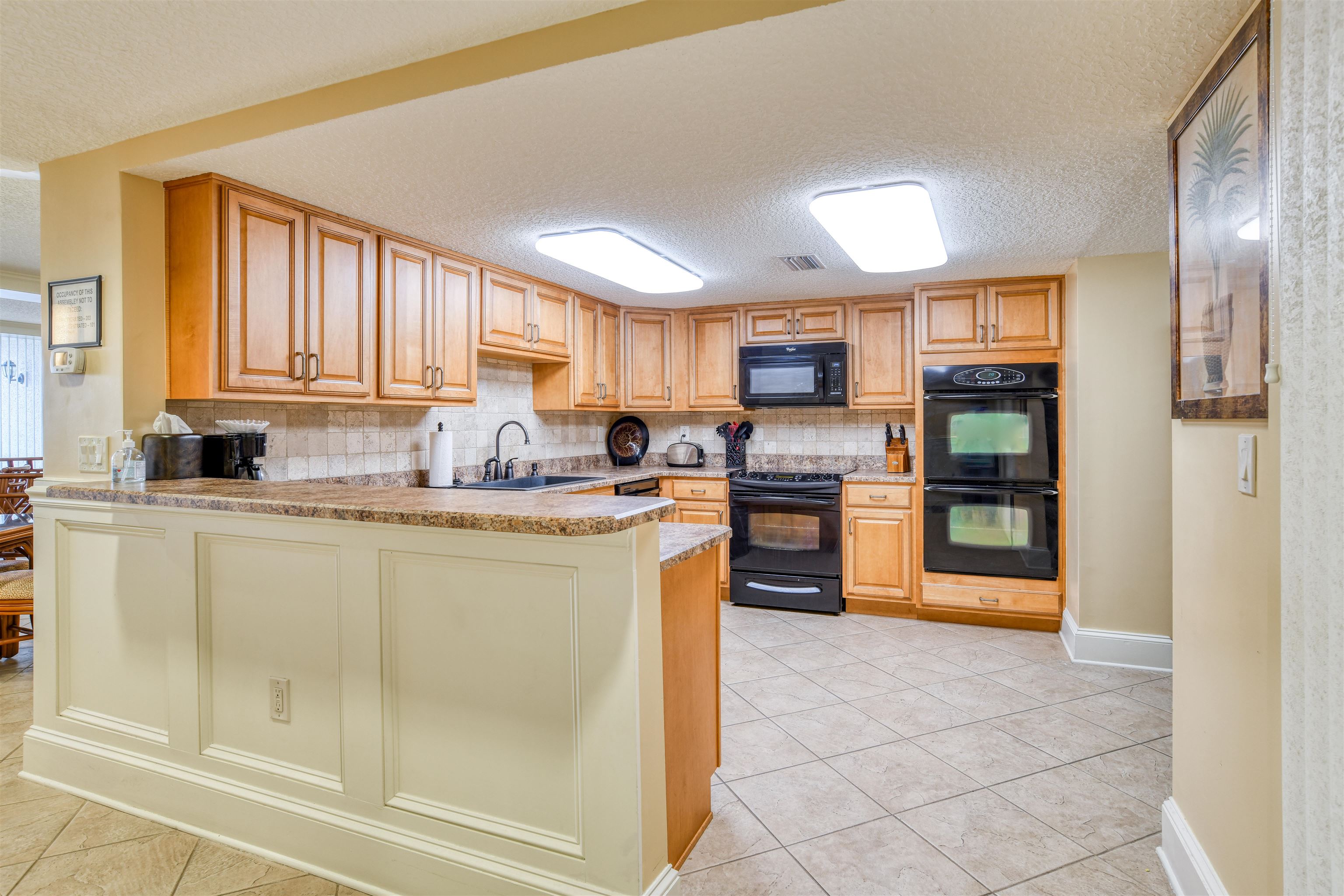 2 Dondanville Road, Unit 101 St. Augustine, FL 32080 - Photo 42 of 50 a kitchen with granite countertop a refrigerator and cabinets