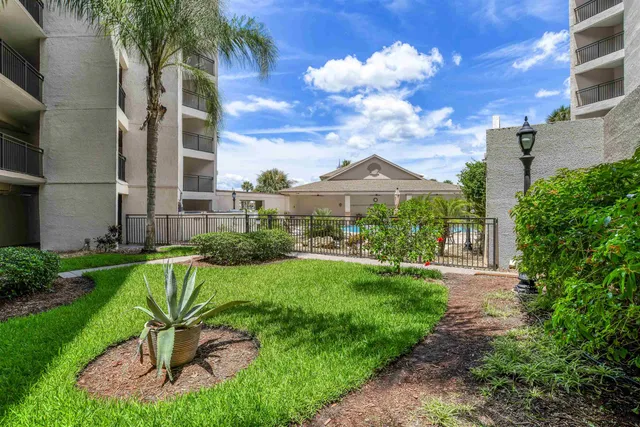 a view of a chair and table in backyard of the house
