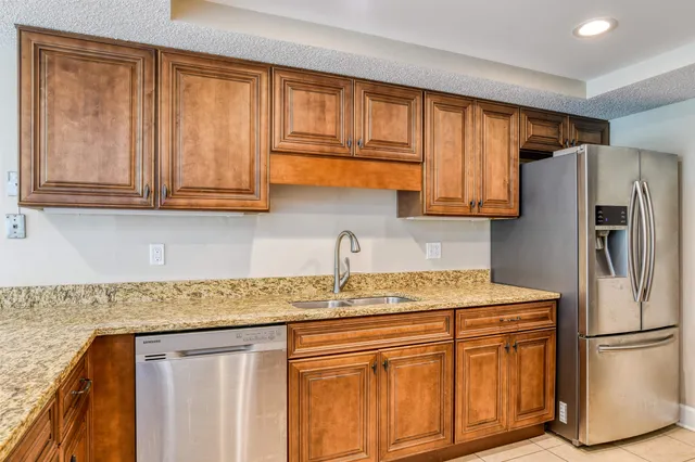 a kitchen with stainless steel appliances granite countertop a refrigerator sink and cabinets