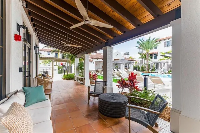 a view of a patio with couches table and chairs and potted plants