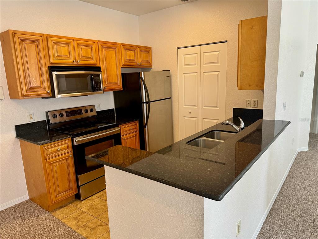832 Grand Regency Point, Unit 204 Altamonte Springs, FL 32714 - Photo 7 of 19 a kitchen with stainless steel appliances a stove microwave and refrigerator