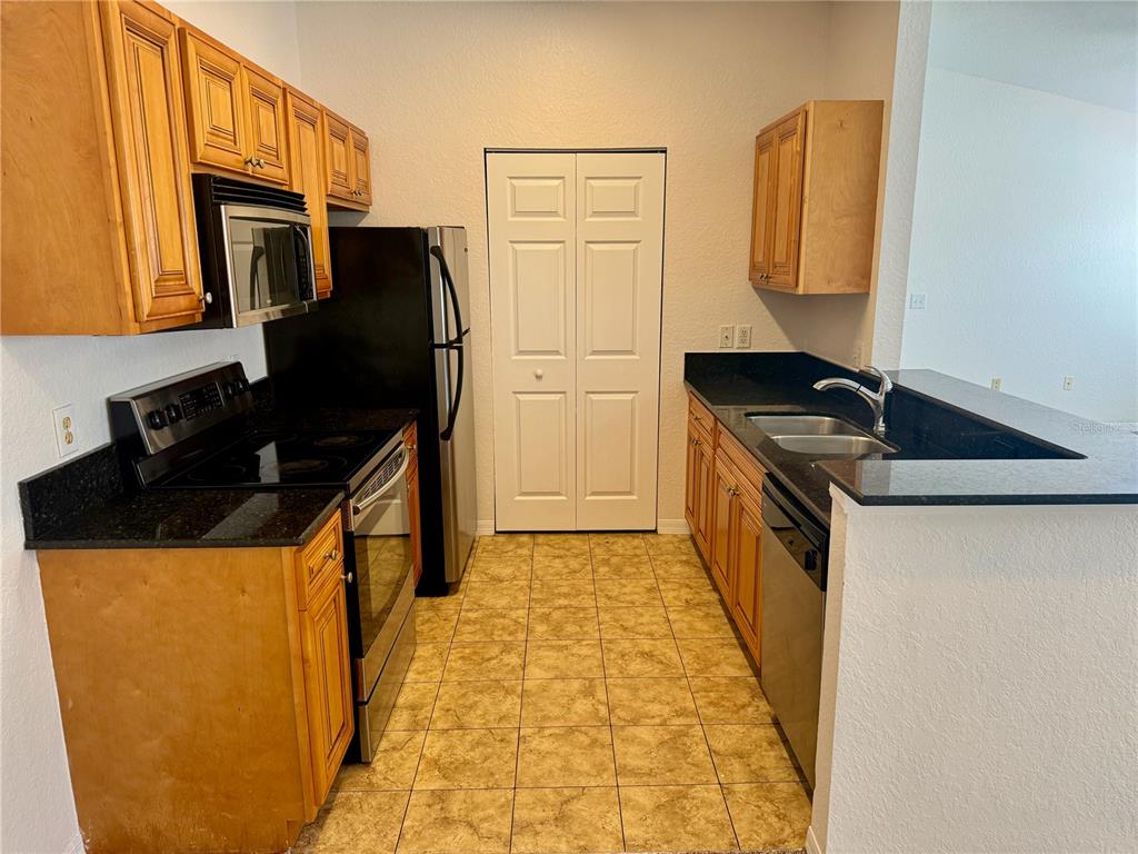 832 Grand Regency Point, Unit 204 Altamonte Springs, FL 32714 - Photo 9 of 19 a kitchen with stainless steel appliances granite countertop a refrigerator and a stove top oven