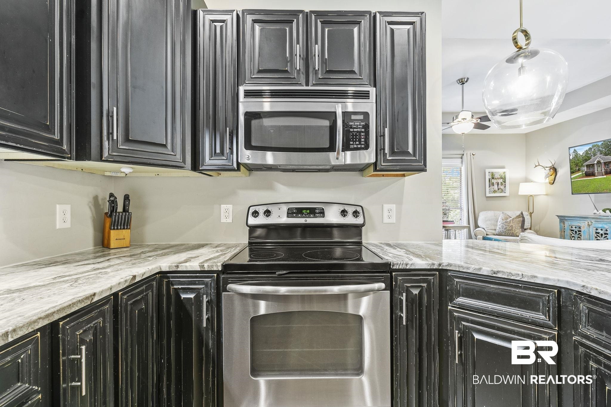 32072 Buzbee Road Daphne, AL 36527 - Photo 15 of 41 Kitchen featuring light stone countertops, decorative light fixtures, and appliances with stainless steel finishes