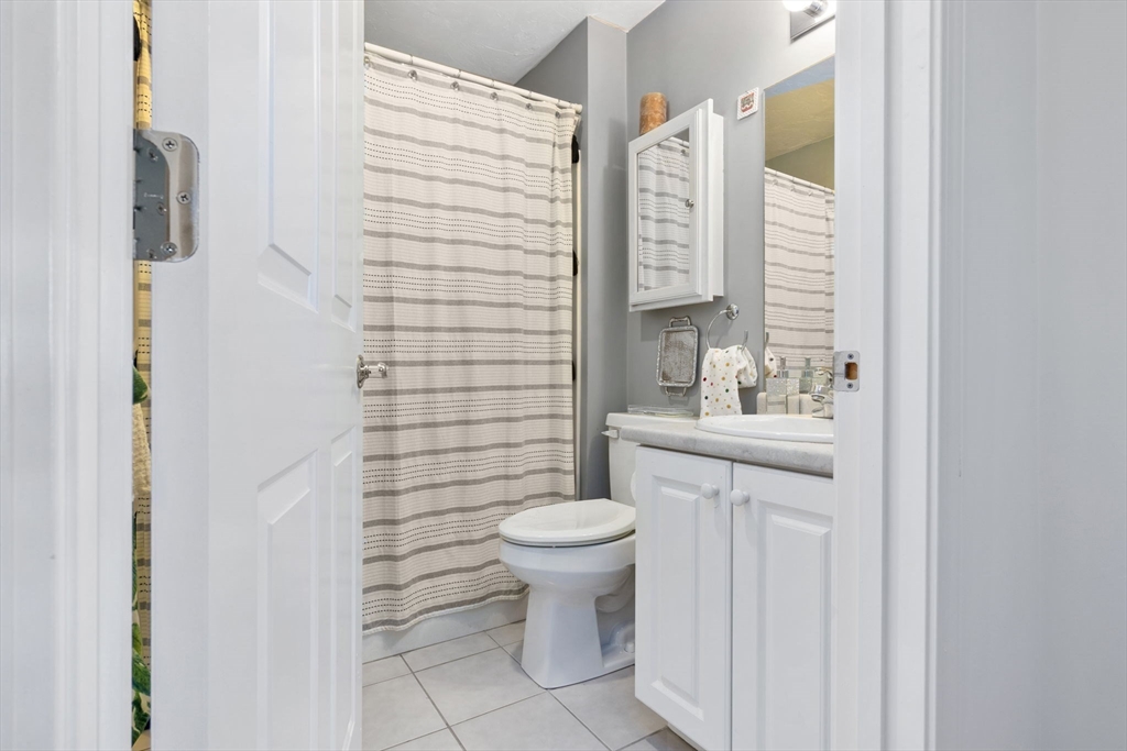 35 Collins Street, Unit 75 Danvers, MA 01923 - Photo 26 of 31 a bathroom with a sink a toilet and shower curtain