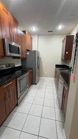 a kitchen with stainless steel appliances granite countertop a refrigerator and a stove top oven
