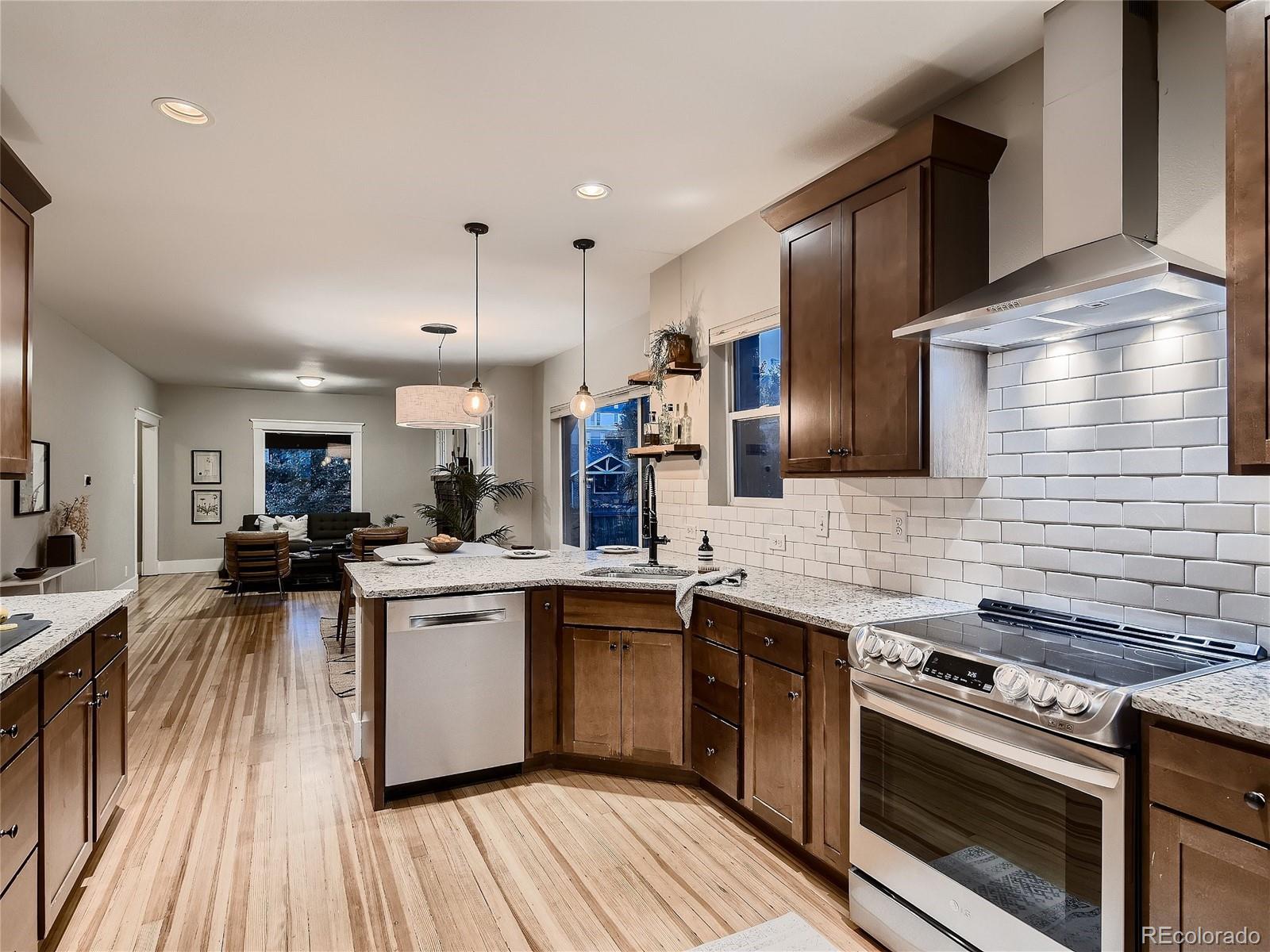1031 Harrison Street Denver, CO 80206 - Photo 11 of 32 a kitchen with stainless steel appliances granite countertop a stove and a sink