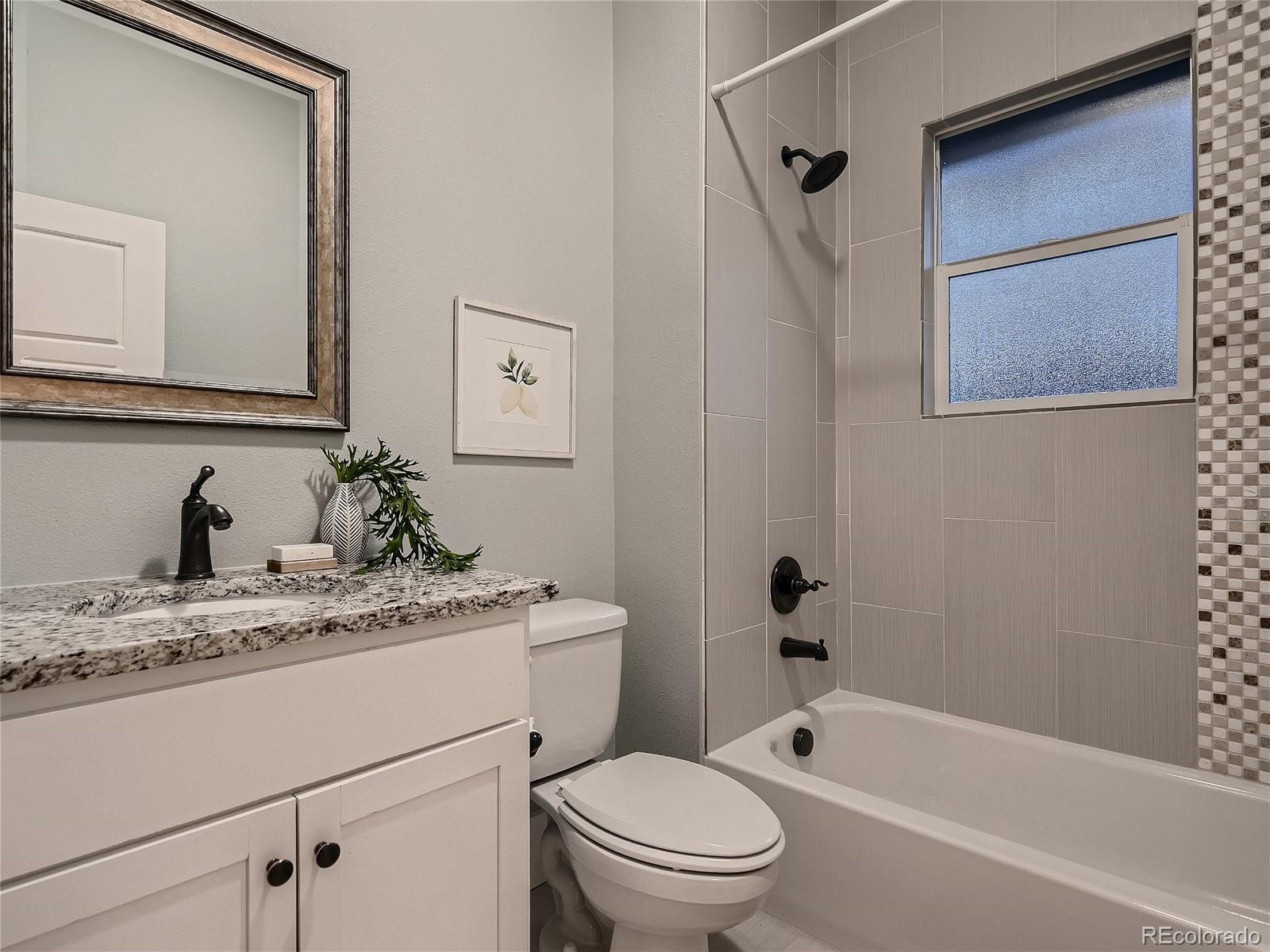 1031 Harrison Street Denver, CO 80206 - Photo 19 of 32 a bathroom with a granite countertop sink toilet and mirror