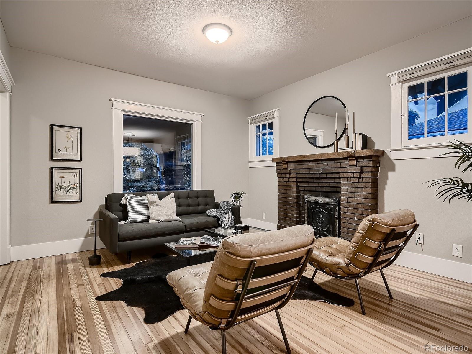 1031 Harrison Street Denver, CO 80206 - Photo 6 of 32 a living room with furniture a fireplace and wooden floor