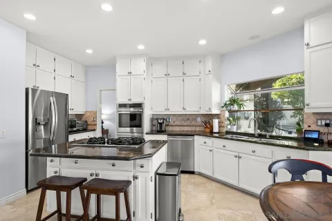 a kitchen with a sink stainless steel appliances and windows