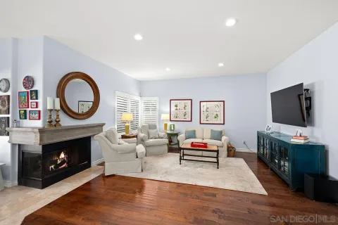 a living room with furniture a rug a fireplace and a flat screen tv